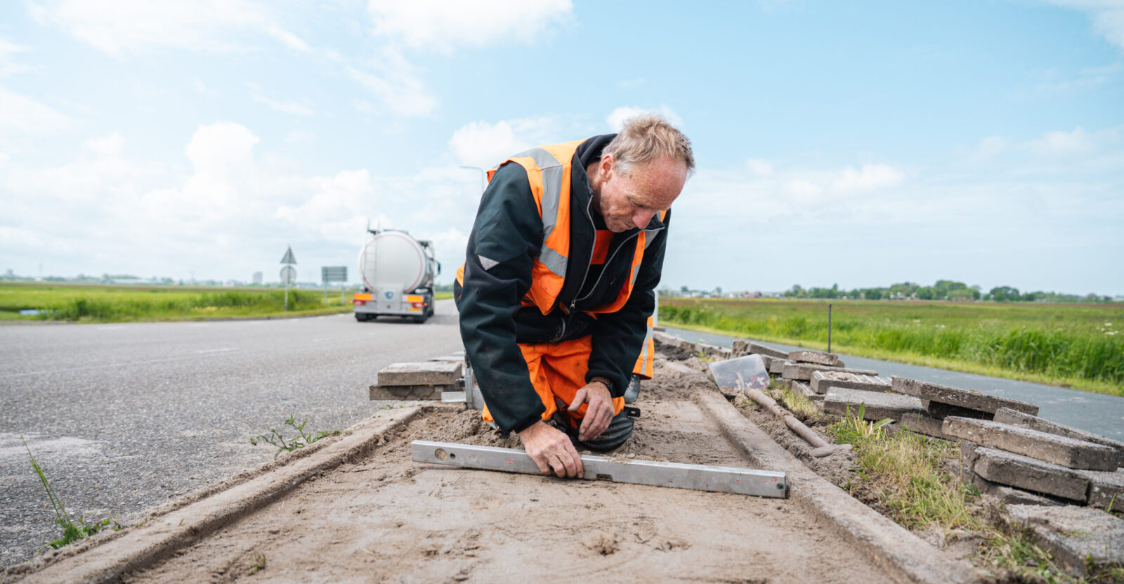 Stratenmaker Rob aan het werk met straatwerk op een projectlocatie.