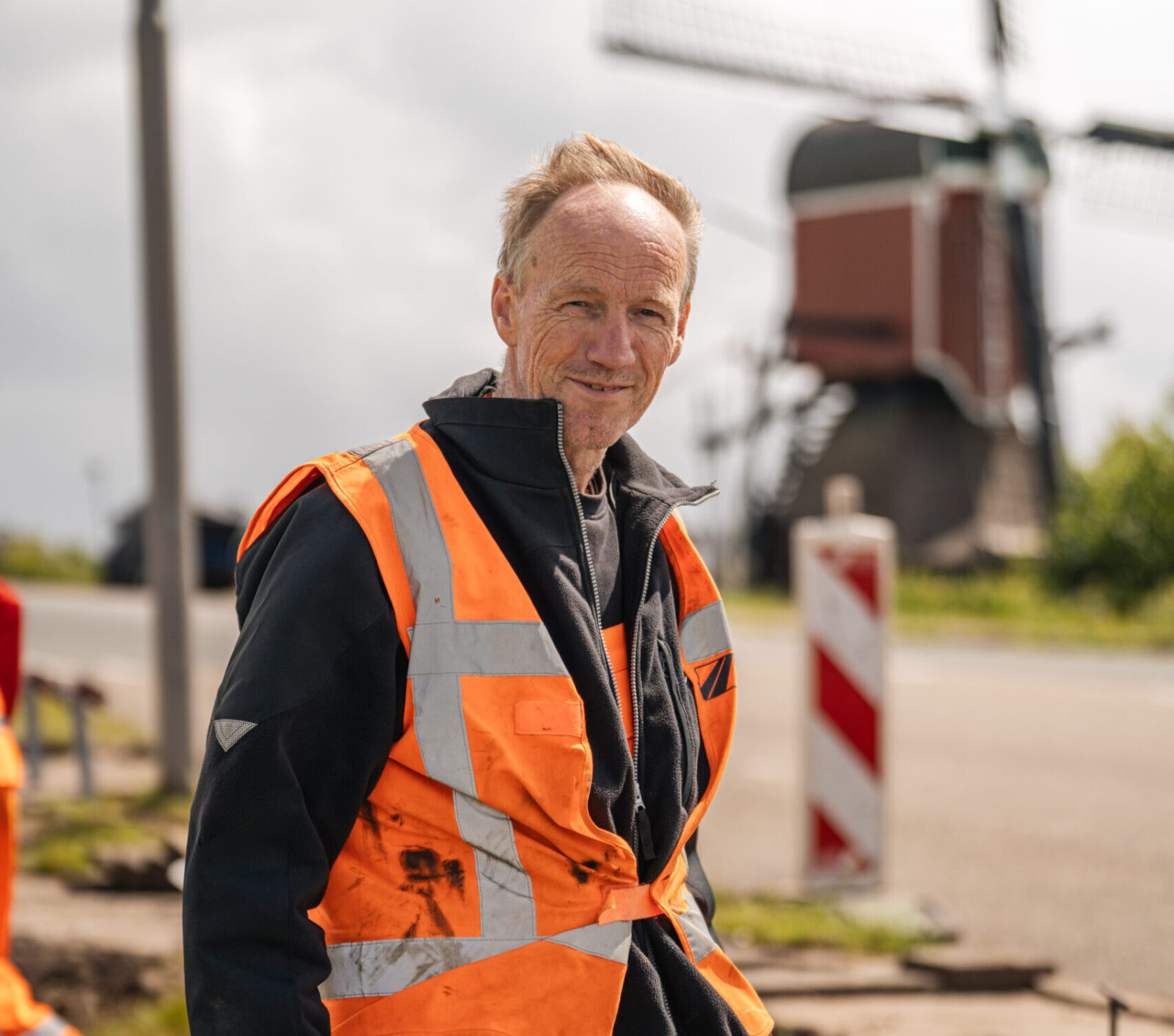 Portret van stratenmaker Rob op de werklocatie tussen het straatwerk.