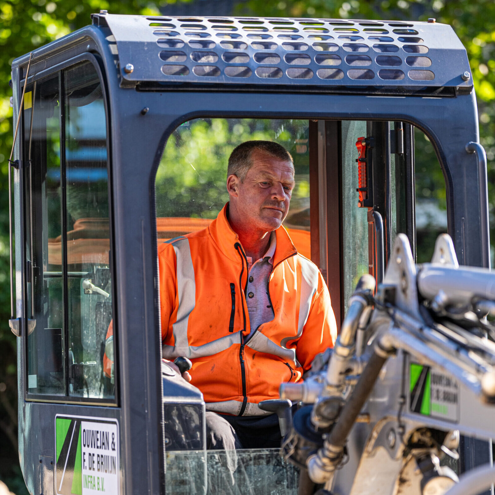 Kraanmachinist aan het werk met een mobiele kraan bij een infraproject.