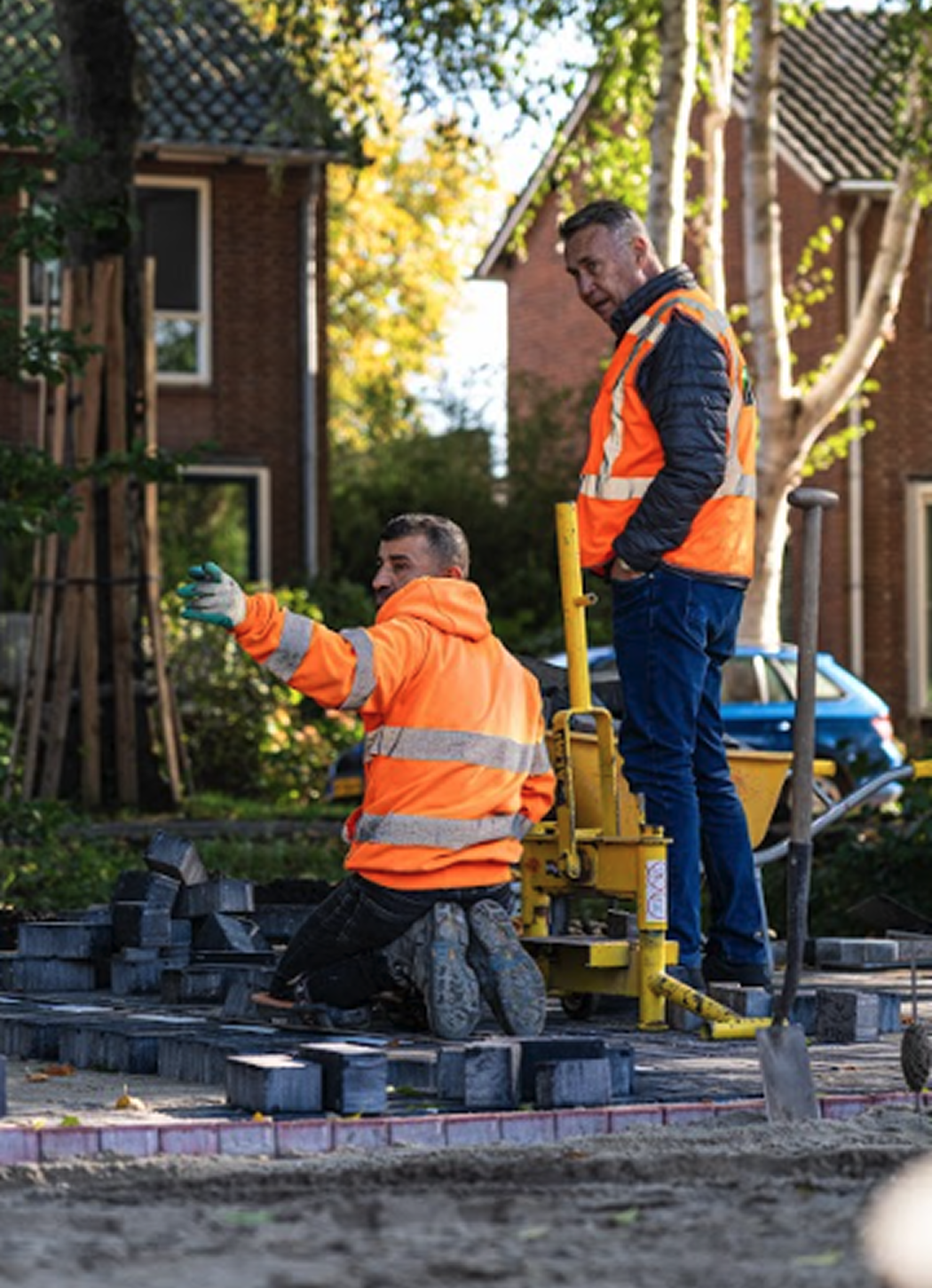 Twee stratenmakers bespreken de werkzaamheden op locatie.